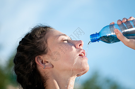 美丽的妇女饮用水 干渴慢跑瓶子成人流动运动员女孩重量快乐运动口渴图片