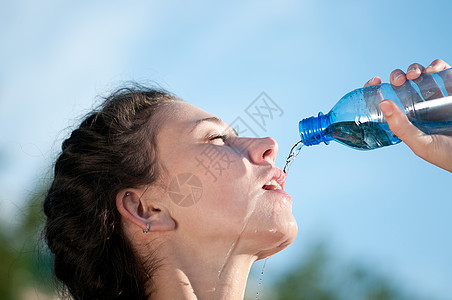 美丽的妇女饮用水 干渴慢跑火车有氧运动瓶子天空运动员流动运动闲暇快乐图片