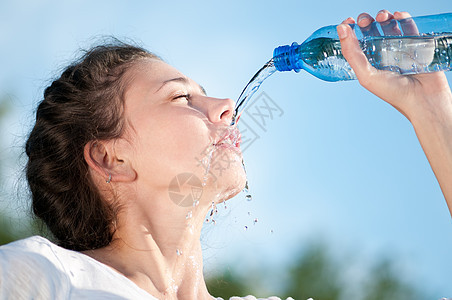 美丽的妇女饮用水 干渴瓶子成人有氧运动矿物女孩慢跑运动员火车重量闲暇图片