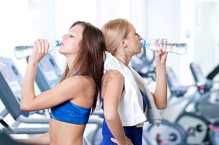 妇女运动后饮用水女士朋友们跑步快乐慢跑口渴跑步机机器微笑保健图片