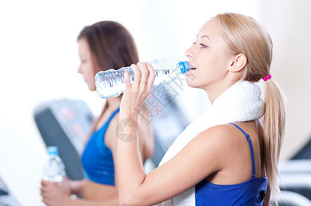 妇女运动后饮用水训练卫生女孩女性友谊微笑朋友们跑步机瓶子跑步图片