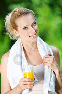妇女锻炼后喝果汁流动运动慢跑活力蓝色公园运动员有氧运动闲暇橙子图片