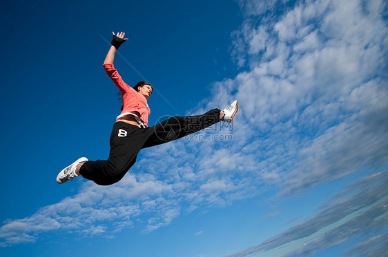 运动女性在天空中跳跃飞翔霹雳舞特技女孩重量休息活力街道房子运动装城市图片