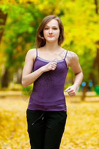 一个年轻女孩在秋天公园奔跑活力越野森林慢跑者慢跑季节女士成人闲暇女性图片
