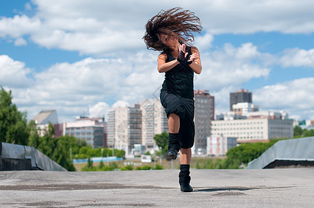 美丽的女孩在城市风景中跳嘻哈舞女性头发成人运动快乐女士天空街道霹雳舞魅力图片