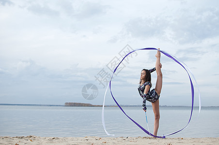 年轻体操女子与丝带跳舞幸福女孩海滩天空乐趣健康女性活动锻炼身体图片