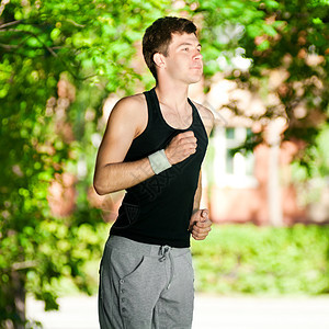 年轻人在公园里慢跑活力赛跑者男人森林叶子活动运动装环境男性快乐图片