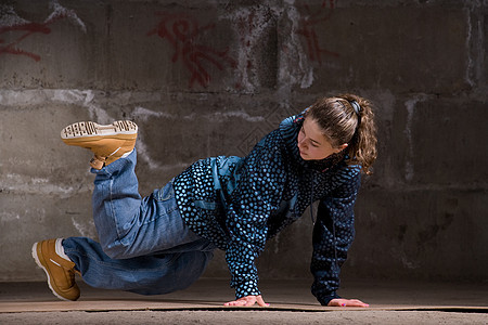 在砖墙上跳现代风格的Hipop舞者说唱青少年衣服黑发特技女士蓝色霹雳舞街道培训师图片