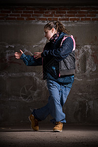 在砖墙上跳现代风格的Hipop舞者霹雳舞青少年说唱靴子牛仔裤情感培训师运动蓝色街道图片
