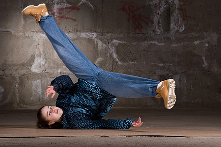 在砖墙上跳现代风格的Hipop舞者衣服培训师女孩靴子蓝色霹雳舞夜生活黑发牛仔裤舞蹈家图片