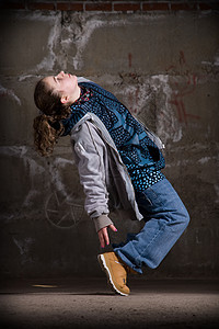 在砖墙上跳现代风格的Hipop舞者青少年情感特技衣服街道靴子夜生活女士女孩蓝色图片