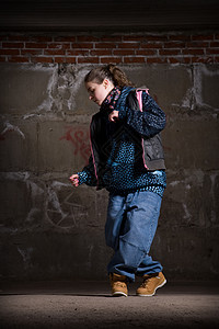 在砖墙上跳现代风格的Hipop舞者运动特技情感牛仔裤霹雳舞黑发青少年演员女士街道图片