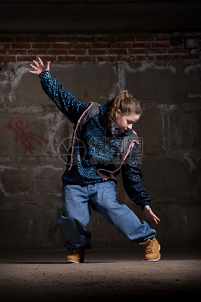 在砖墙上跳现代风格的Hipop舞者衣服夜生活霹雳舞说唱女孩青少年蓝色培训师街道特技图片