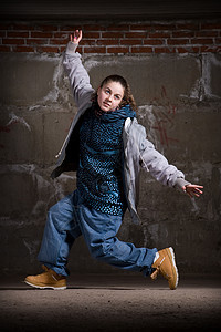 在砖墙上跳现代风格的Hipop舞者情感街道女孩运动演员女士说唱牛仔裤衣服靴子图片