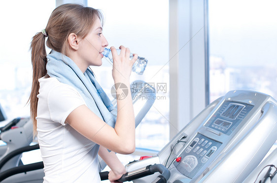 妇女在健身饮用水中的饮水福利健身房青少年蓝色肌肉慢跑流动运动员娱乐女孩图片