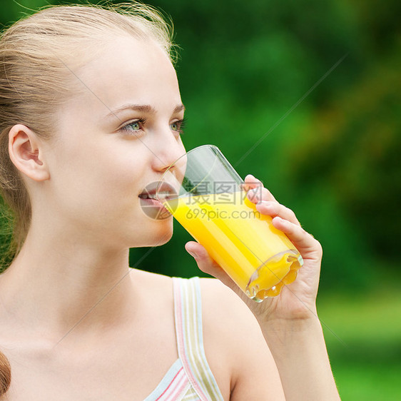年轻女孩喝橙汁 外门水果果汁玻璃公园活力有氧运动运动女性蓝色火车图片