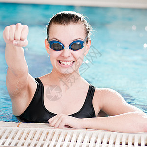 在游泳池中黑护目镜中的女子游泳者微笑成人乐趣运动员游泳女士蓝色女孩套装图片