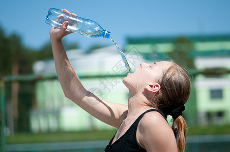 年青妇女锻炼后饮用饮用水青少年闲暇女性成人女孩深色矿物口渴瓶子快乐图片