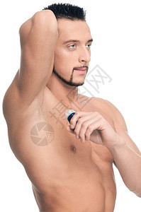 英俊的年轻人施香水青年化妆品头发男人胡子皮肤均衡眼睛男性护理图片