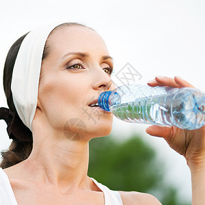 户外运动中的妇女饮用水赛跑者瓶子运动福利天空有氧运动运动员口渴蓝色身体图片