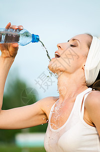 户外运动中的妇女饮用水身体运动装女士公园女孩口渴矿物天空行动蓝色图片
