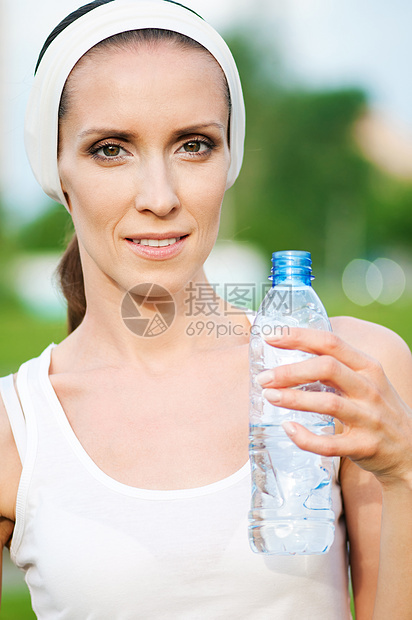 户外运动中的妇女饮用水矿物保健蓝色女孩运动有氧运动公园运动装训练瓶子图片