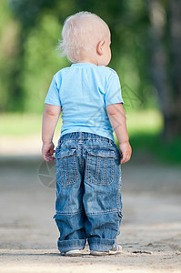 快乐的小男孩在绿色公园闲暇行动草地乐趣喜悦晴天头发场地花园男性图片