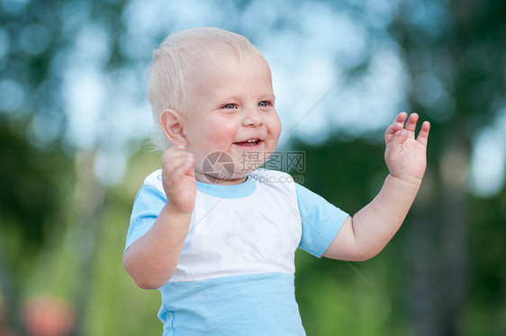 快乐的小男孩在绿色公园晴天喜悦男生乐趣草地森林季节青年公园行动图片