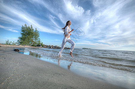 运动妇女跑在海上海岸蓝色光束乐趣有氧运动火车训练速度天空太阳海洋图片