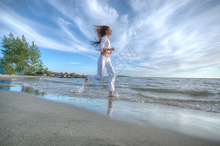 运动妇女跑在海上海岸重量有氧运动火车乐趣女士海洋海滩日落女孩太阳图片