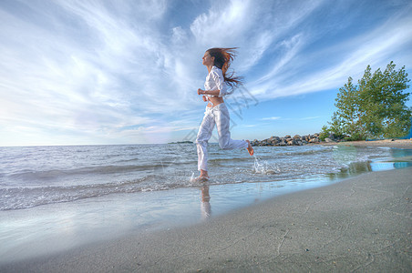 运动妇女跑在海上海岸有氧运动活动活力重量速度跑步火车女士赛跑者慢跑图片