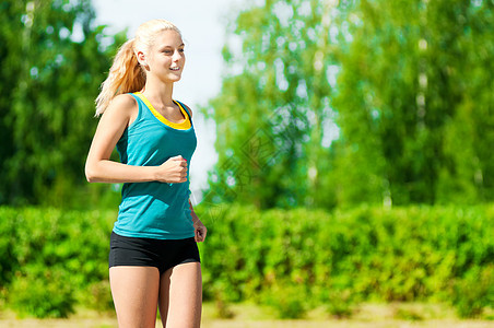 青年女子在绿色公园中奔跑季节街道赛跑者女士活动娱乐训练活力女孩环境图片