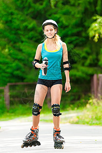 穿溜冰鞋的黑发年轻女人慢跑公园滚筒青少年街道运动跑步训练娱乐头盔图片