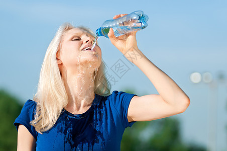 户外运动中的妇女饮用水女孩蓝色跑步保健赛跑者瓶子女性身体运动装活力图片
