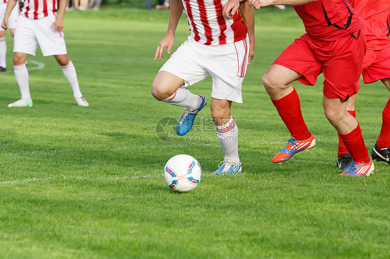 足球运动员的腿在比赛中滑动乐趣竞赛季节攻击草地场地短袜活动情感精力图片