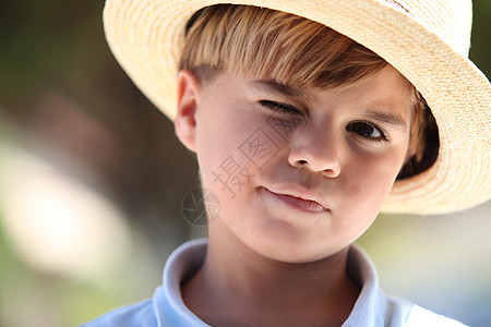 一个戴着草帽的小男孩的近身图片