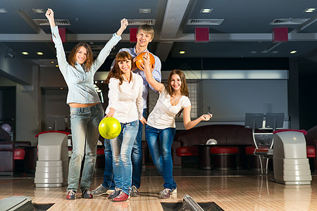一群玩保龄球的年轻朋友游戏胡同投球活动女性娱乐竞赛手臂男人女孩图片