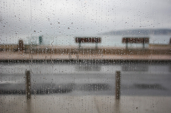 从窗户后面的雨淋湿的一天长凳灰色玻璃气候天气风暴长椅图片
