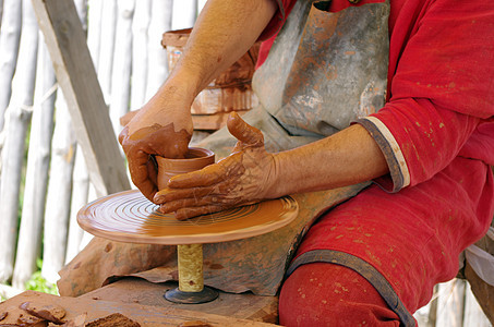 以陶器的手 在圆上创造一个土罐工匠压力陶瓷血管手工业车轮模具手指水壶作坊图片