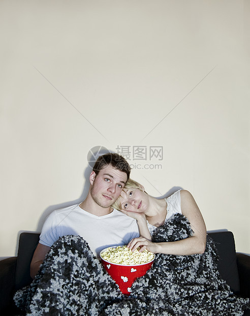 年轻夫妇在看电视吃爆米花图片