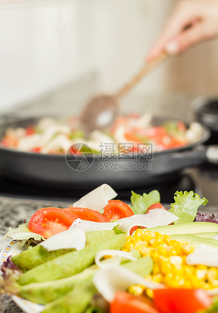 特写新鲜沙拉菜盘和女性在锅里做饭绿色平底锅蔬菜玉米片玉米沙拉食物胡椒红色洋葱图片