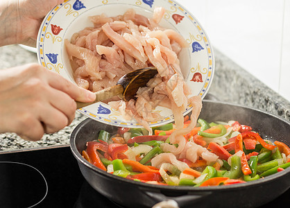 特写女性烹饪蔬菜和鸡锅中的鸡肉玉米片红色绿色玉米平底锅食物洋葱沙拉胡椒图片