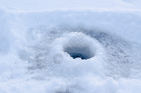 在冰中钻入的冰洞 准备在冰上钓鱼图片