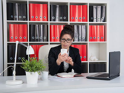 办公室中的商业妇女阳光白领阶层人士计时器科技电脑显示器桌子手雕商务背景图片