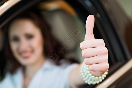 坐在车里的年轻女人 举起拇指发动机乐趣座位学习者成就手指幸福女士商业商务图片