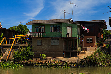 沿河的泰国传统住房 与自然和自然共同生活场景城市文化旅行建筑村庄建筑学土地植物首都图片