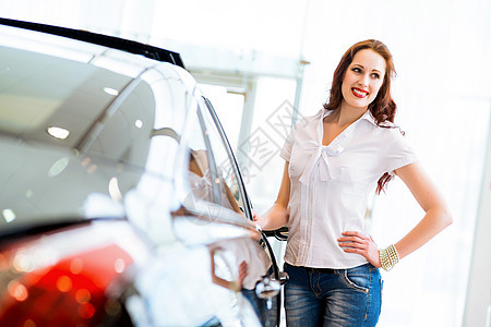 站在汽车旁边的年轻妇女引擎协议运输男性女性零售推销员车辆交易机械图片
