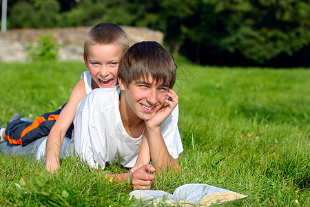 少年和有书的小孩幸福小伙子喜悦假期青少年兴趣青年兄弟男性公园图片
