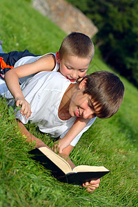 少年和有书的小孩公园阅读兄弟青年衣服拥抱乐趣青少年快乐阳光图片