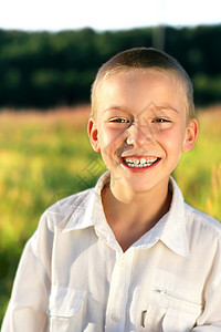 男孩肖像男性牙齿微笑天空蓝色幸福衣服孩子金发阳光图片